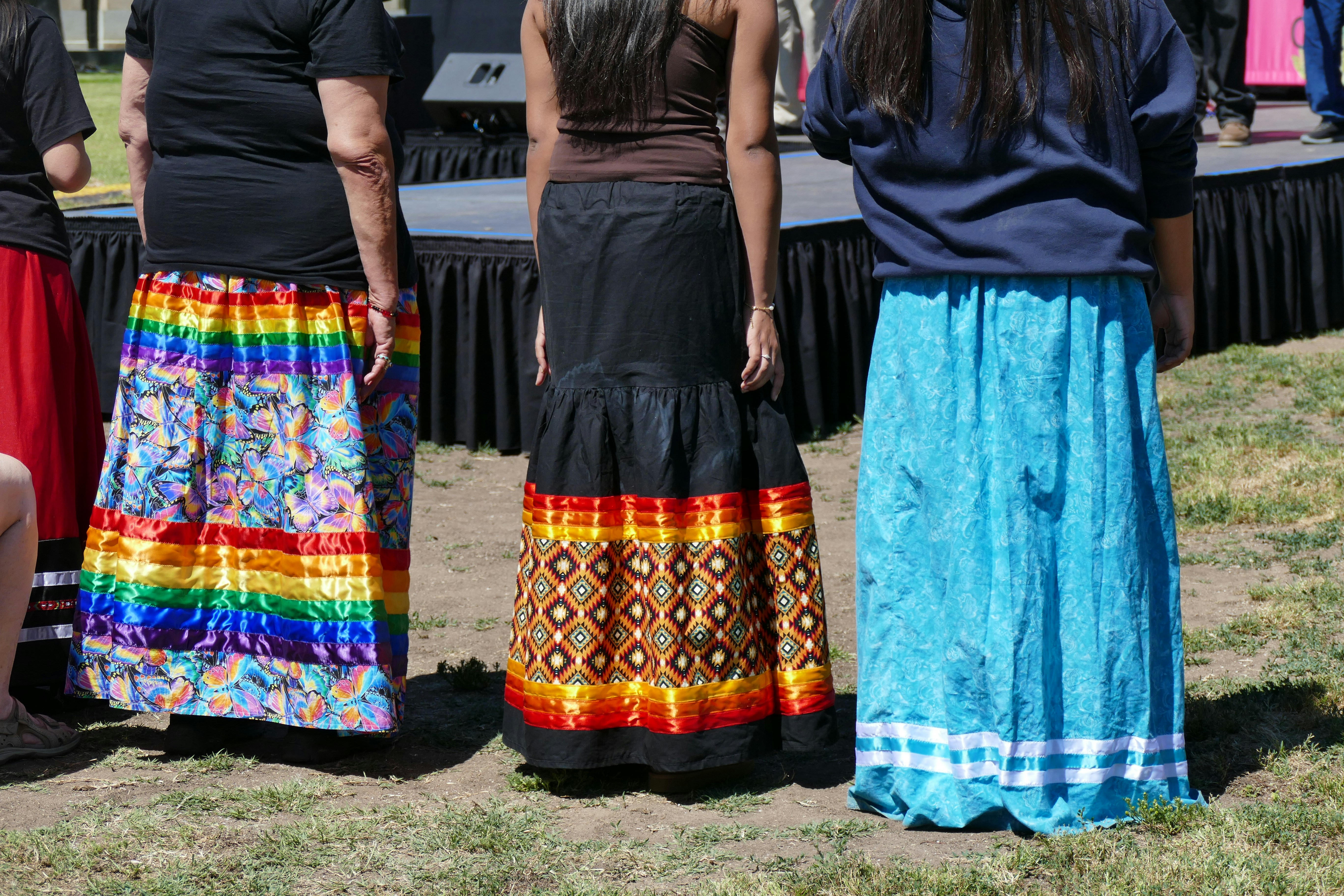 Women in colourful ceremonial dress at an outdoor gathering