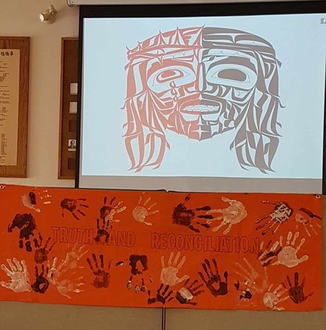 Coast Salish-style Indigenous Jesus art above a Truth and Reconciliation handprint banner